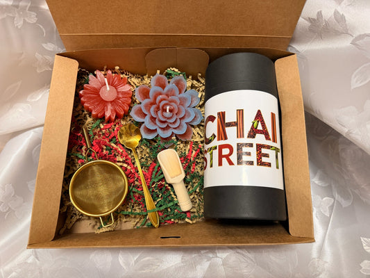 Chai Street gift box containing a tea tin, flower-shaped candles, gold spoon, wooden scoop, and tea infuser