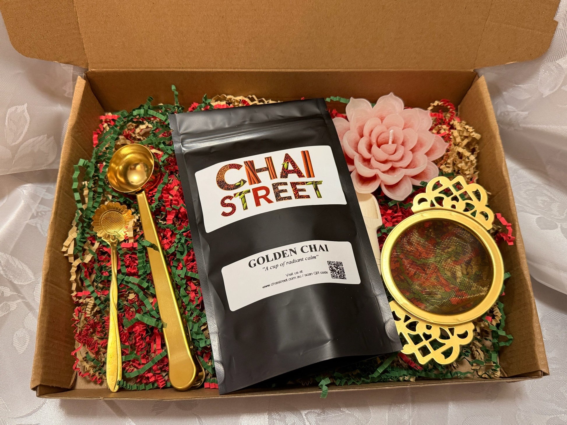 Golden Chai gift box featuring Chai Street tea pack, gold spoon, tea strainer, and decorative flower candle